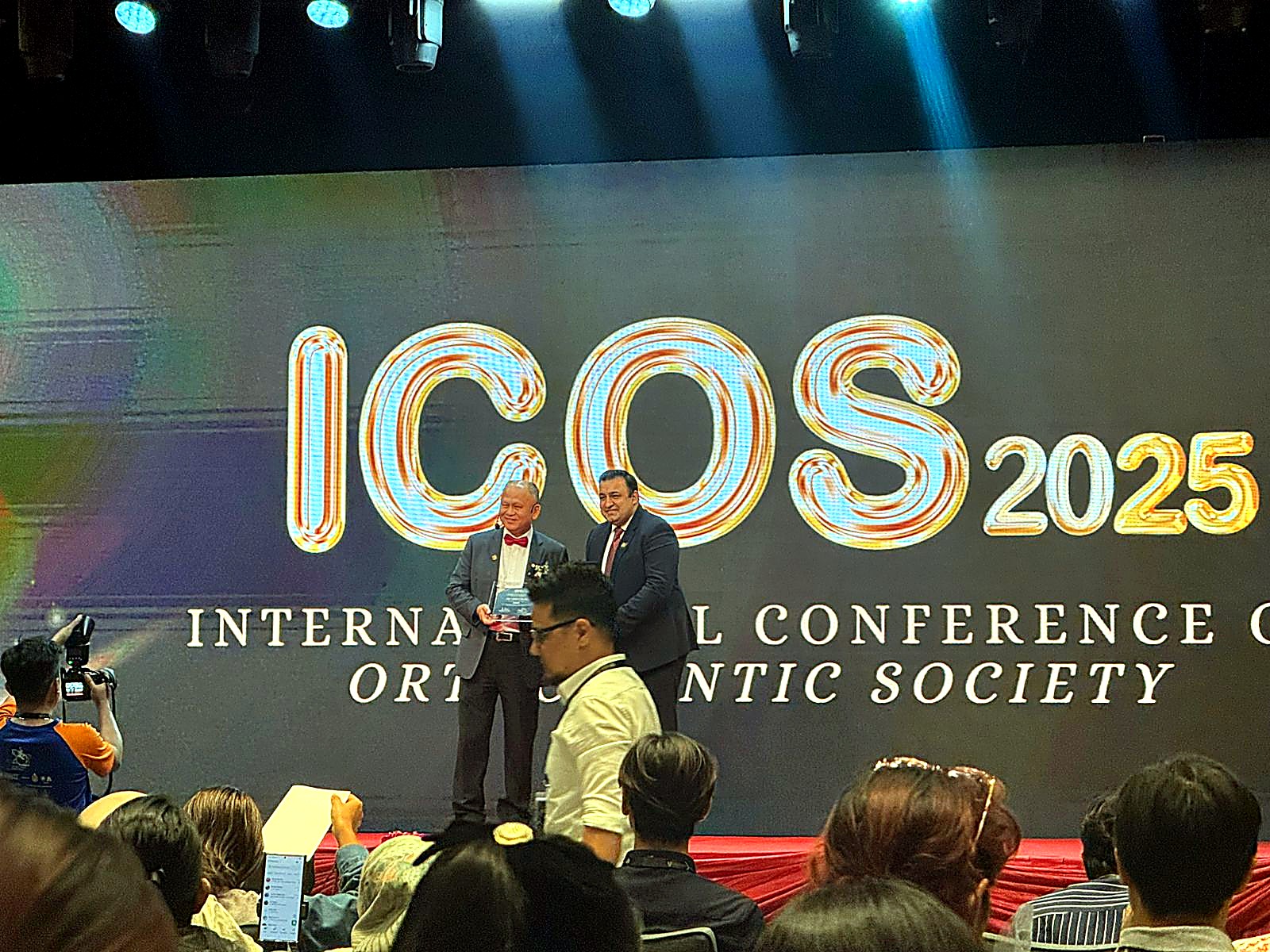 AHD International receiving an award on stage at ICOS 2025